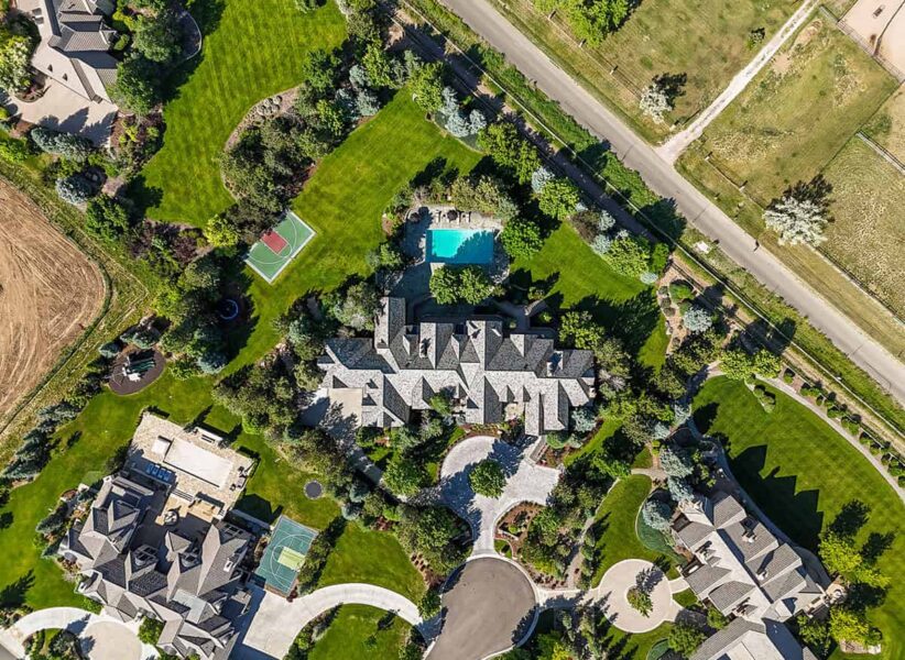true aerial view of new home build highlighting new roof, pool, mature trees, and sport court with neighbors to either side ONE Residential Builders Denver