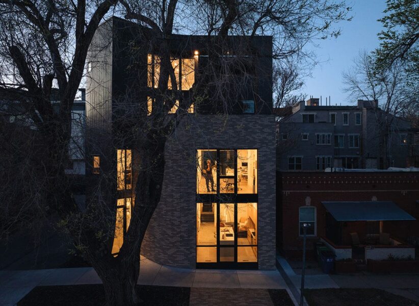 hero image of top portion of contemporary home at sunset with large windows and bright lights inside ONE Residential Builders Denver