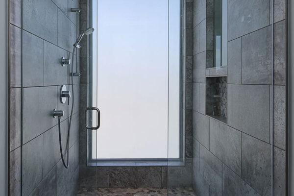 contemporary shower with glass door, dual shower heads and shelf for necessities ONE Residential Builders Denver