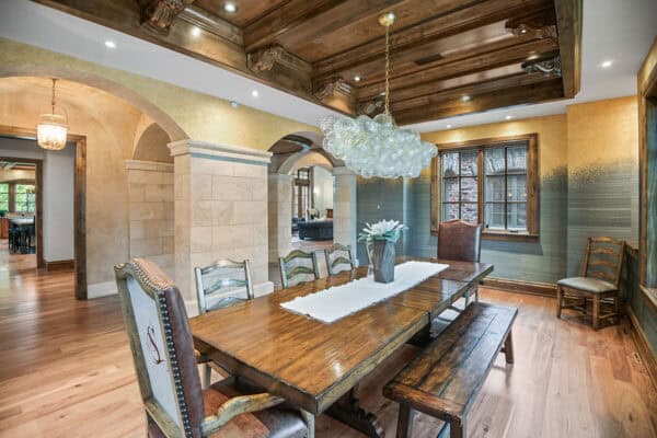home's unique features include wood dining table with chairs and wood bench, unique wallpaper, and ornament-like chandelier ONE Residential Builders Denver