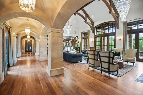 large living room with wood trusses and marble columns, wood floors, and large light fixtures ONE Residential Builders Denver