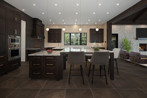 traditional home with open concept from kitchen including high island, new cabinets into living area with modern furnishings and fireplace ONE Residential Builders Denver