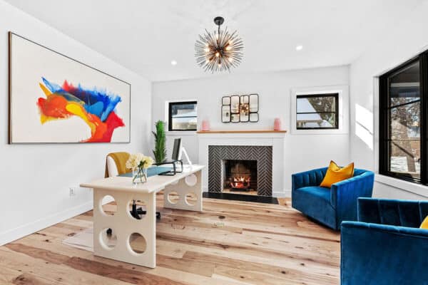 colorful and unique office with bright blue chairs and complimentary art with desk with open circles on the sides ONE Residential Builders Denver