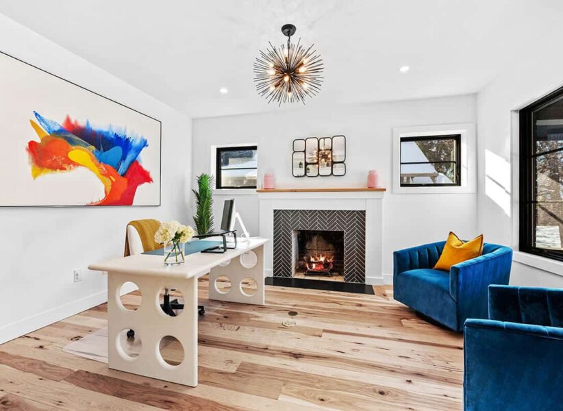 colorful and unique office with bright blue chairs and complimentary art with desk with open circles on the sides ONE Residential Builders Denver