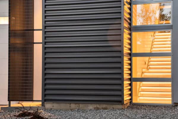 close up view of metal finishes outside and brightly lit indoor staircase inside ONE Residential Builders Denver
