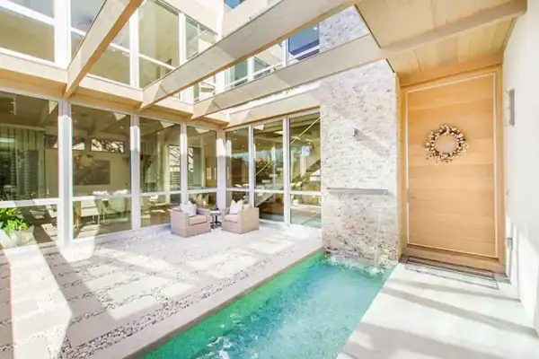 outdoor patio of modern home with large water feature plus concrete and stone deck ONE Residential Builders Denver