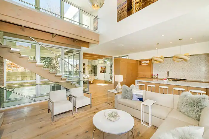 living room with off-white, modern furniture and open concept kitchen with large marble island ONE Residential Builders Denver